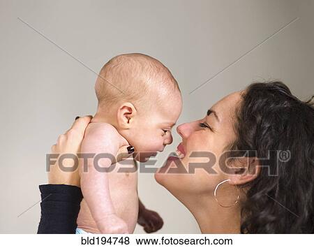 Stock Photo - Mother holding newborn baby face to face. Fotosearch
