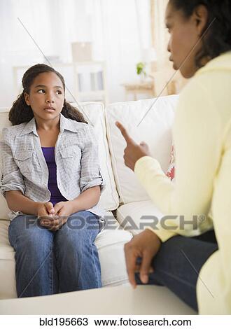 Stock Image - Mother lecturing daughter in living room. Fotosearch