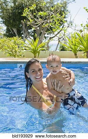 Mother playing with son in swimming pool View Large Photo Image Stock Photo - Mother playing with son in swimming pool. Fotosearch