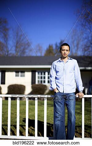 Pacific Islander man standing near home fence View Large Photo Image Stock Image - Pacific Islander man standing near home fence. Fotosearch