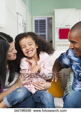 Stock Photograph - Parents tickling daughter. Fotosearch