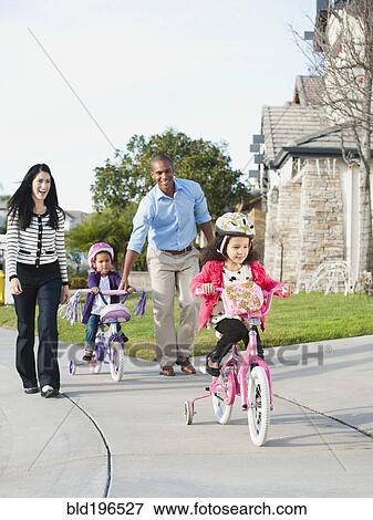 Stock Photo - Parents watching children ride bicycles. Fotosearch