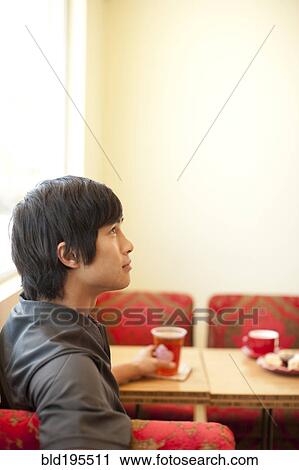 Stock Image - Pensive mixed race man looking up. Fotosearch