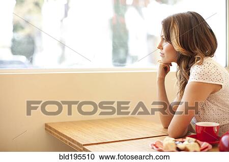 Stock Image - Pensive woman looking out window. Fotosearch