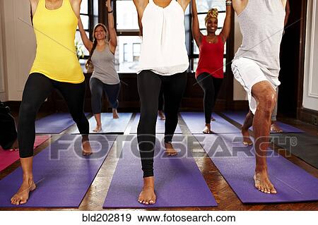 Stock Photo - People practicing yoga in class. Fotosearch