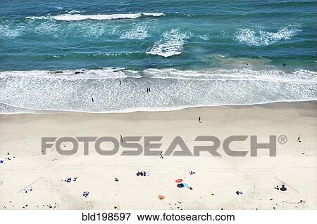 Stock Photo - People relaxing on sunny beach. Fotosearch