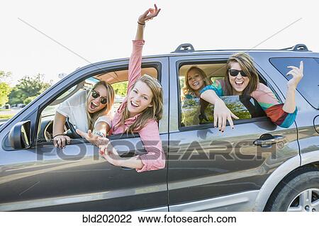 Stock Image - Playful friends in car. Fotosearch