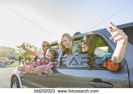Stock Image - Playful friends in car. Fotosearch