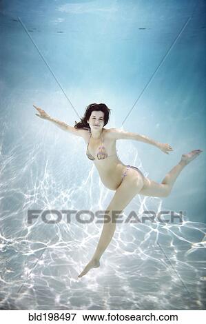 Pregnant Caucasian woman swimming underwater View Large Photo Image Stock Photo - Pregnant Caucasian woman swimming underwater. Fotosearch