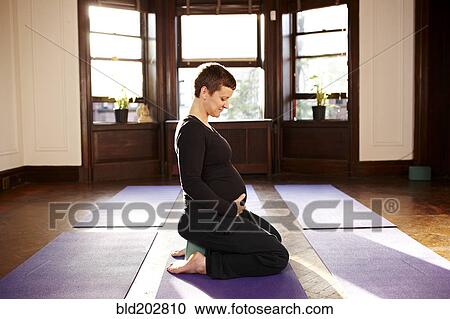 Pregnant woman sitting on yoga mat View Large Photo Image Stock Image - Pregnant woman sitting on yoga mat. Fotosearch