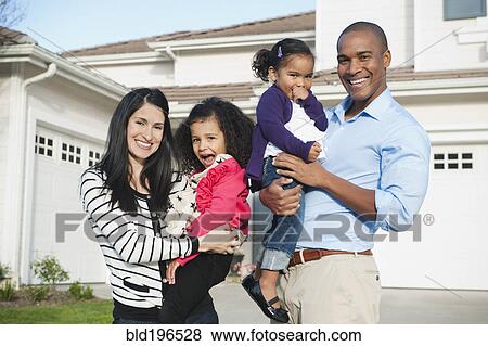 Stock Photo - Proud parents and daughter standing in driveway. Fotosearch