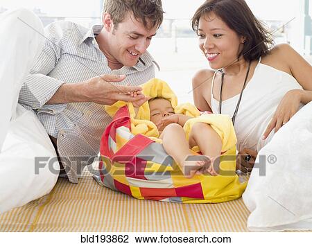 Proud parents looking at sleeping daughter View Large Photo Image Stock Image - Proud parents looking at sleeping daughter. Fotosearch
