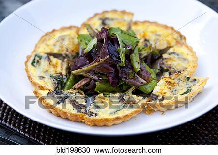 Stock Image - Quiche on plate with salad. Fotosearch