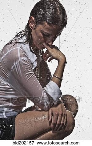 Stock Photo - Rain falling on Caucasian businesswoman. Fotosearch