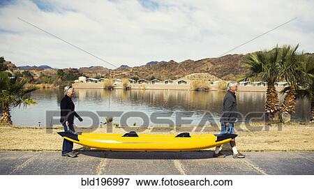 Senior Caucasian couple carrying kayak View Large Photo Image Stock Photo - Senior Caucasian couple carrying kayak. Fotosearch