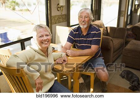 Stock Photograph - Senior Caucasian couple sitting in motor home. Fotosearch