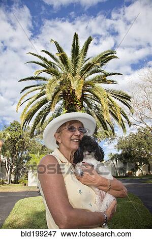 Stock Photo - Senior Caucasian woman holding dog. Fotosearch