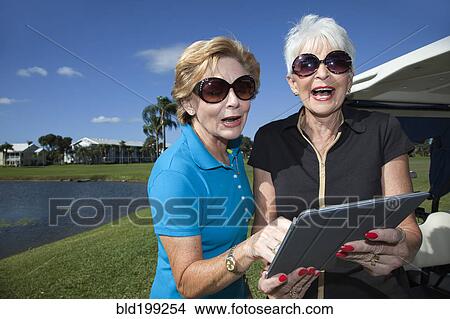 Picture - Senior Caucasian women looking at digital tablet. Fotosearch