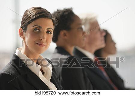 Stock Image - Serious business people listening in meeting. Fotosearch