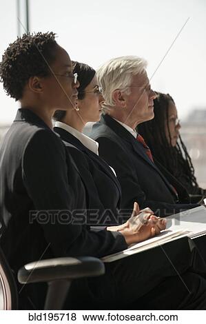 Stock Photo - Serious business people listening in meeting. Fotosearch