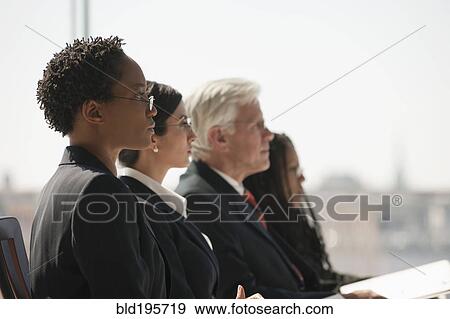 Serious business people listening in meeting View Large Photo Image Stock Photo - Serious business people listening in meeting. Fotosearch