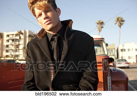 Serious Caucasian man sitting on back of truck View Large Photo Image Stock Image - Serious Caucasian man sitting on back of truck. Fotosearch