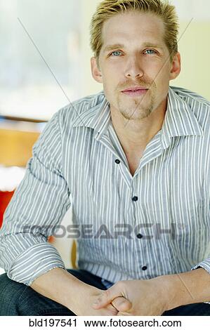 Stock Image - Serious Caucasian man with hands clasped. Fotosearch