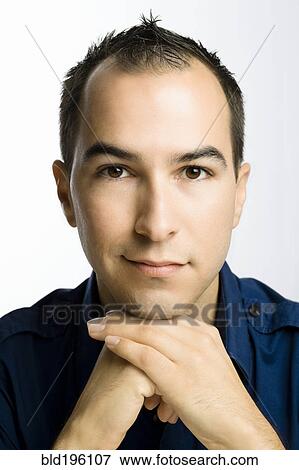 Stock Photo - Serious Caucasian man with hands on chin. Fotosearch