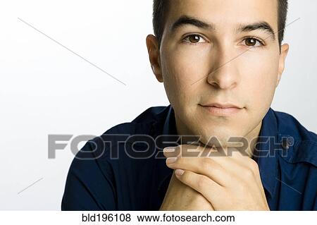 Stock Photo - Serious Caucasian man with hands on chin. Fotosearch
