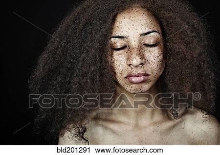 Stock Image - Serious, freckled mixed race woman. Fotosearch