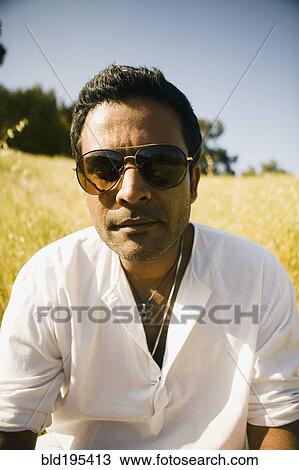 Stock Image - Serious mixed race man in field. Fotosearch
