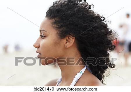 Stock Photo - Serious mixed race woman on beach. Fotosearch