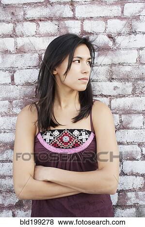 Stock Photo - Serious mixed race woman with arms crossed. Fotosearch