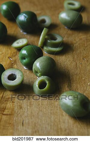 Stock Photo - Sliced green olives on cutting board. Fotosearch