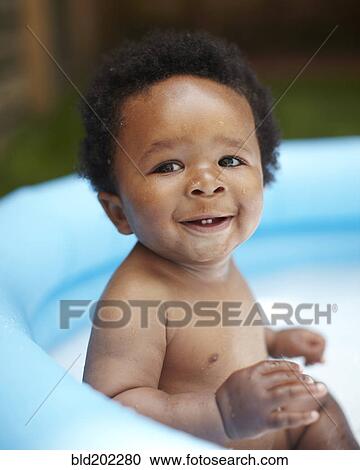 Stock Image - Smiling African American baby in swimming pool. Fotosearch