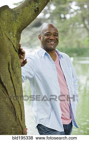 Stock Photo - Smiling African American man in park. Fotosearch