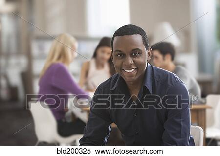 Smiling Black man studying with friends View Large Photo Image Stock Photography - Smiling Black man studying with friends. Fotosearch