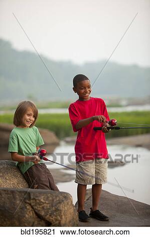 Stock Image - Smiling boys fishing together. Fotosearch