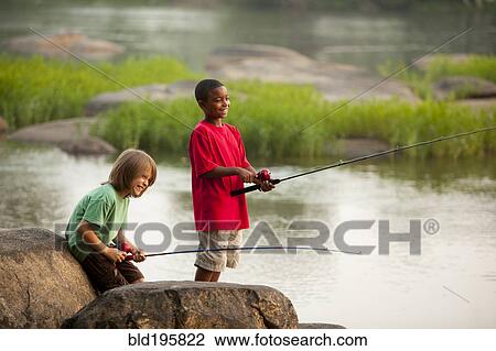 Stock Image - Smiling boys fishing together. Fotosearch