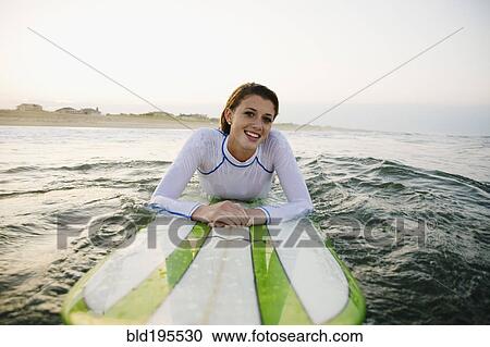 Smiling Caucasian teenage girl leaning on surfboard in ocean View Large Photo Image Stock Image - Smiling Caucasian teenage girl leaning on surfboard in ocean. Fotosearch