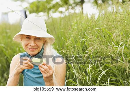 Smiling Caucasian woman eating in grass View Large Photo Image Stock Photo - Smiling Caucasian woman eating in grass. Fotosearch