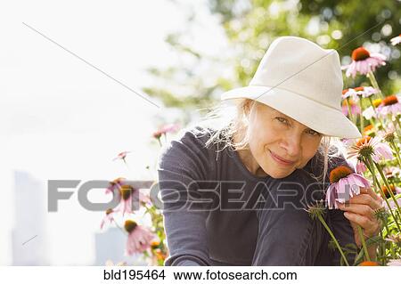 Smiling Caucasian woman holding flower View Large Photo Image Picture - Smiling Caucasian woman holding flower. Fotosearch