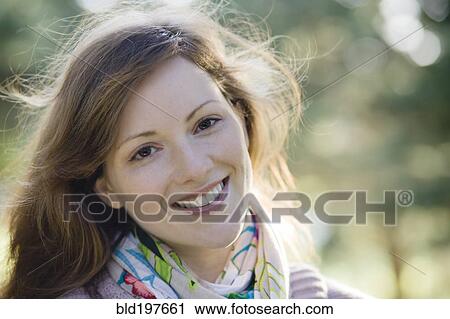 Stock Image - Smiling Caucasian woman outdoors. Fotosearch