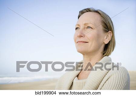 Smiling Caucasian woman standing on beach View Large Photo Image Picture - Smiling Caucasian woman standing on beach. Fotosearch