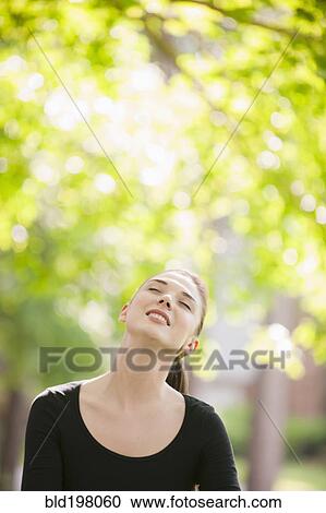 Smiling Caucasian woman standing outdoors View Large Photo Image Stock Image - Smiling Caucasian woman standing outdoors. Fotosearch