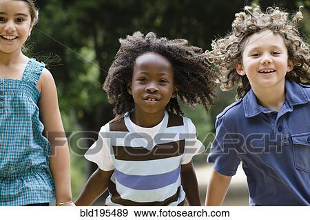 Stock Photo - Smiling children holding hands and running. Fotosearch