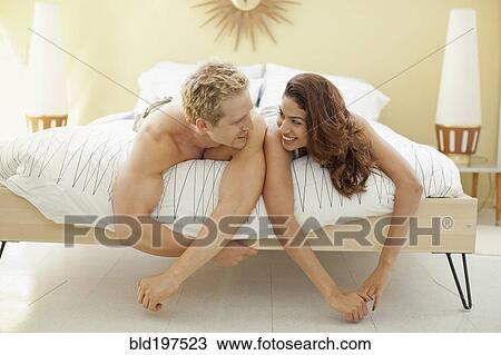 Smiling couple laying in bed View Large Photo Image Stock Image - Smiling couple laying in bed. Fotosearch