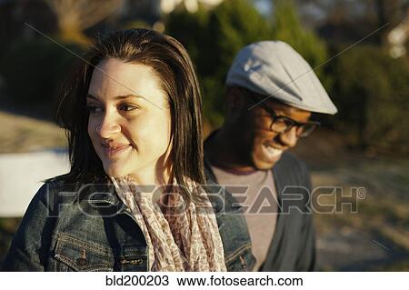 Stock Image - Smiling couple standing outdoors. Fotosearch