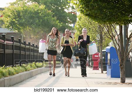 Stock Image - Smiling friends shopping together. Fotosearch