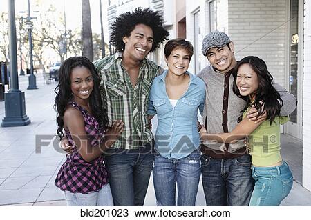 Smiling friends standing together hugging View Large Photo Image Stock Image - Smiling friends standing together hugging. Fotosearch